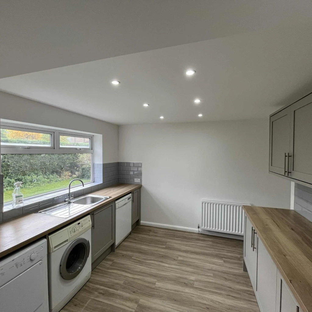 Kitchen renovation with grey units, wood-effect worktops and laminate flooring